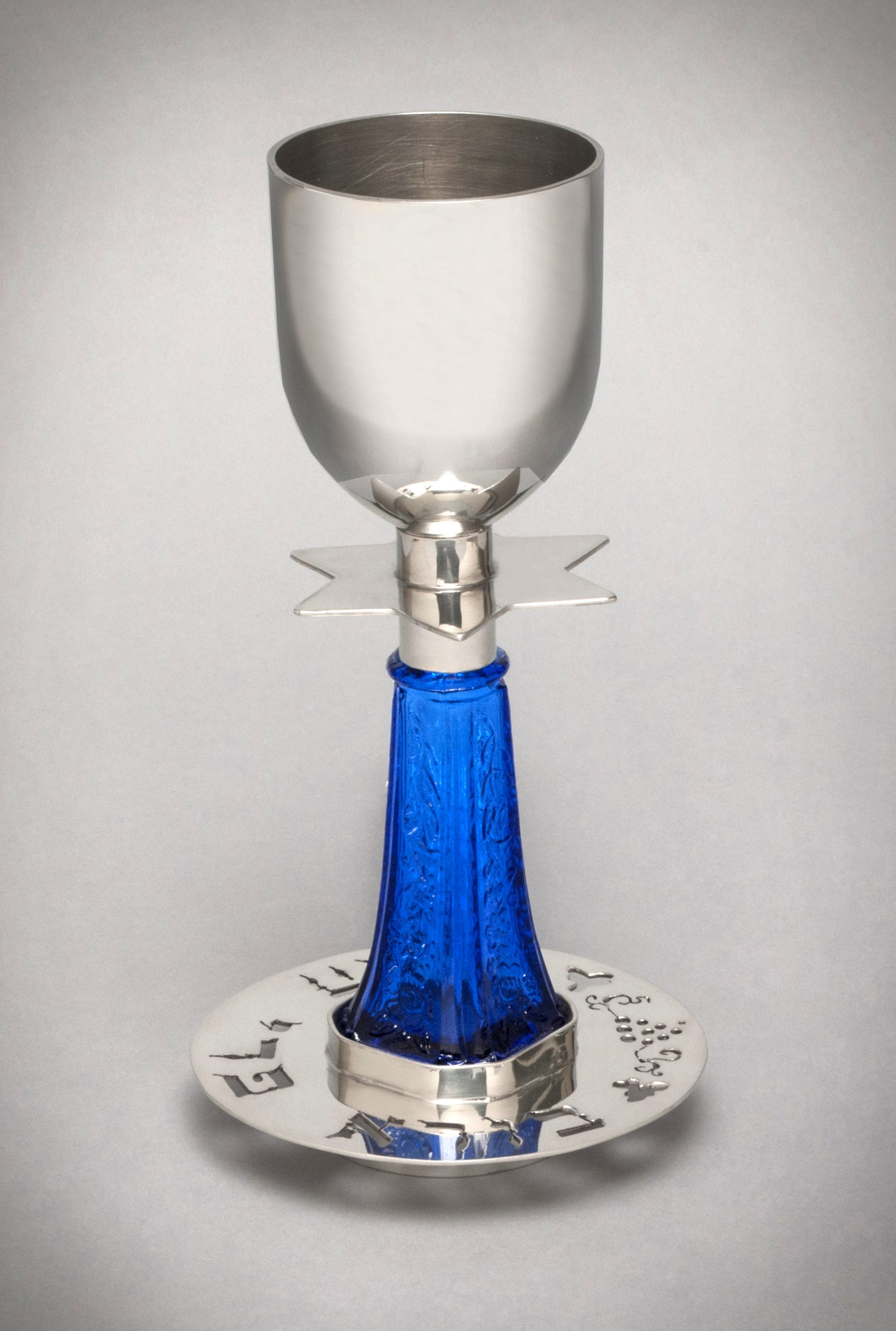 Frann Addison’s original works of Judaica acknowledge the past, yet offer new and beautiful forms in celebration of Jewish family life. She uses Hebrew calligraphy blended with the masterful use of pewter, brass, copper, glass and found objects to make her one-of-a-kind Judaica pieces. She has been featured extensively in numerous publications and her work can be found in the permanent collections of the Museum of American Jewish History, Philadelphia, the B’nai B’rith Klutznick Museum, Washington, DC, and the National Heritage Museum, Lexington, MA. "Kiddush Cup for a Jewish Wedding", pewter and repurposed salt shaker; pierced, soldered and riveted. Action, MA 01720;Metal