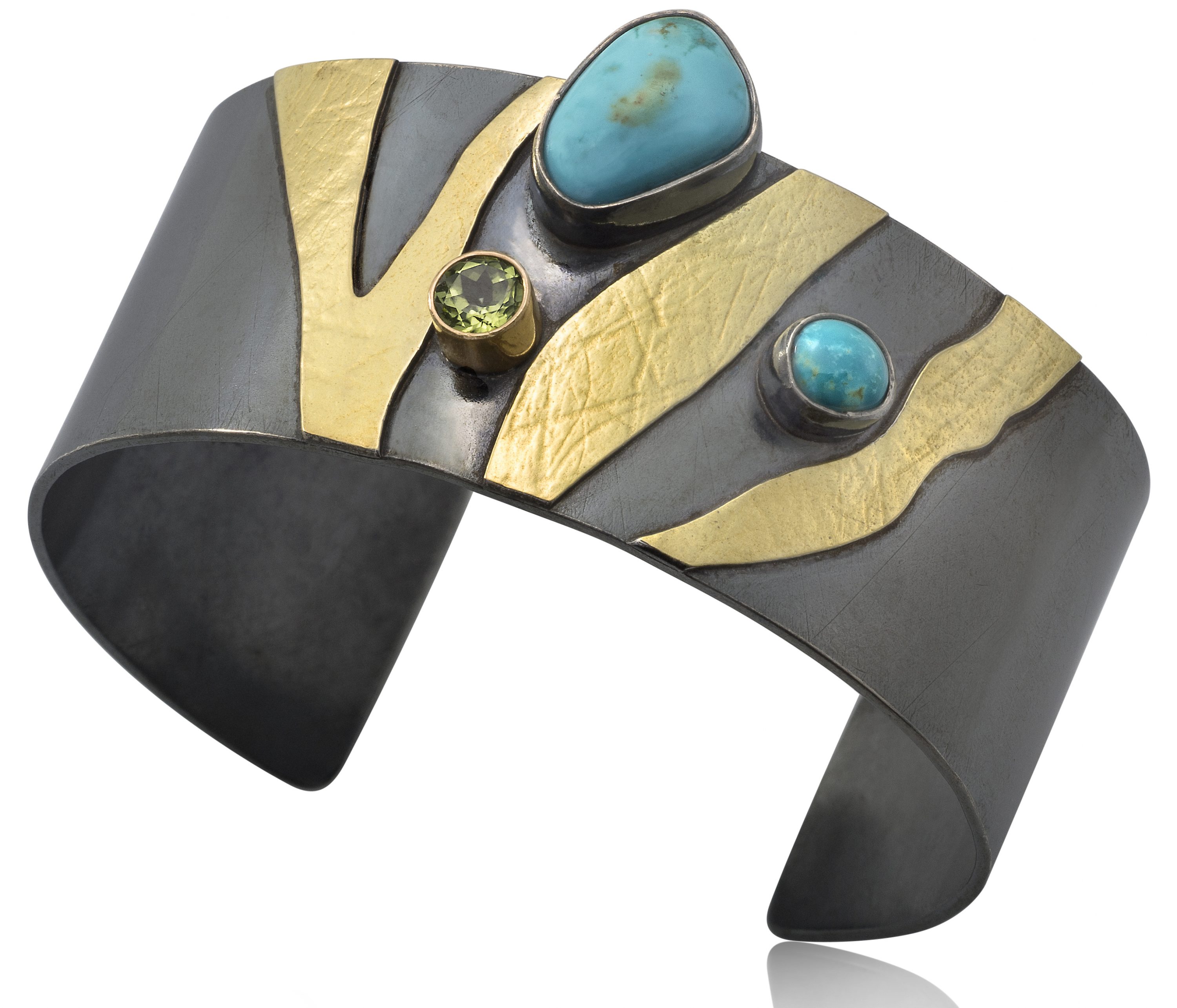 Lynn Harrisberger's one-of-a-kind jewelry made with extremely rare natural Blue Moon turquoise reflects her love of the West’s wide-open spaces, rugged hills, and endless blue skies.Her jewelry has received national recognition. She received the 2015 NICHE award in silver and stones and was a 2017 NICHE Award Finalist in fine jewelry. Her work has been featured in many magazines, including Art Jewelry, Cowboys and Indians, Lapidary Journal and the cover of Best in American Made. Blue Moon Turquoise & Peridot Zebra Cuff. Blackened Sterling Silver, 14 &1 8kt Gold, Rare, Natural Blue Moon Turquoise, Peridot.
