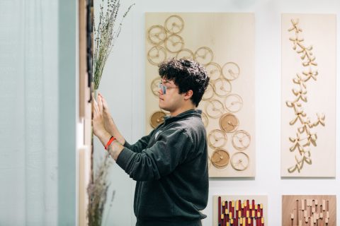 A patron plays with the interactive art pieces at Lines By Two.